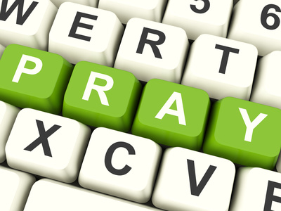 Computer keyboard with the word 'Pray' picked out in green keys