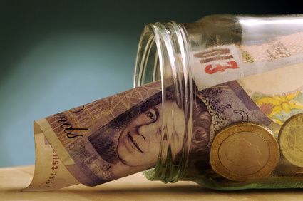 Jar of British coins and notes on its side