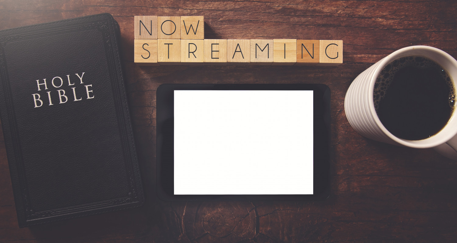 The words Now Streaming in printers blocks, bible ipad and coffee mug