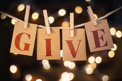 Photo of brown paper tags pegged on a line spelling the word 'Give'.